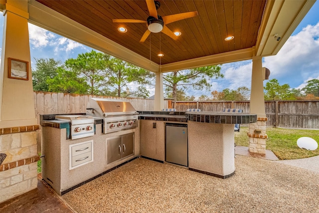 view of patio with an outdoor kitchen, a grill, and ceiling fan