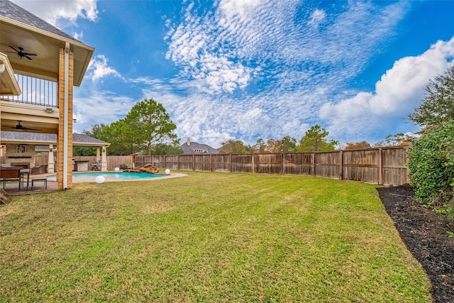 view of yard with a fenced in pool, ceiling fan, and a balcony