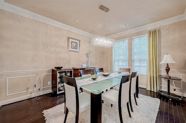 dining room featuring dark hardwood / wood-style floors, crown molding, a wealth of natural light, and a chandelier