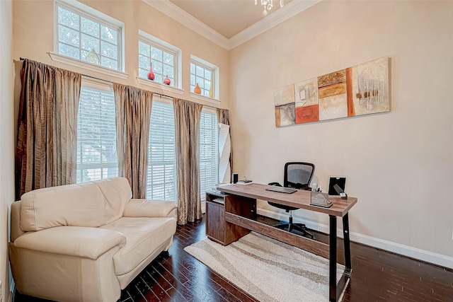 office area with plenty of natural light, dark hardwood / wood-style flooring, ornamental molding, and a high ceiling