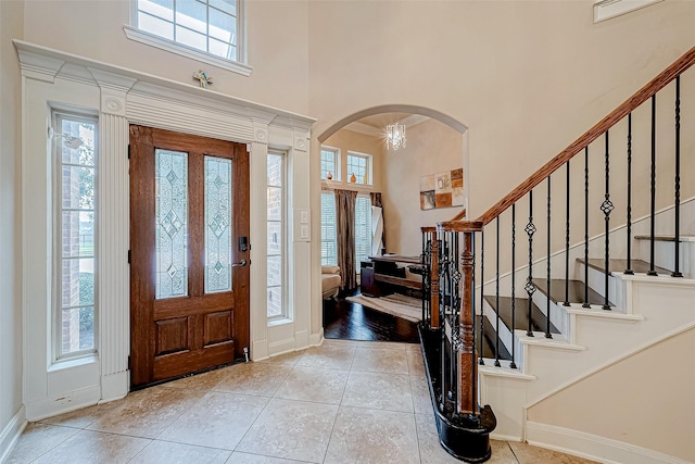 tiled entryway with a chandelier and a wealth of natural light