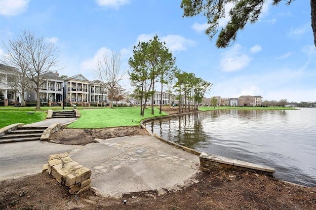 surrounding community featuring a lawn and a water view