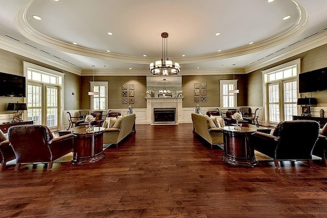 living room featuring a chandelier, dark hardwood / wood-style floors, and a tray ceiling