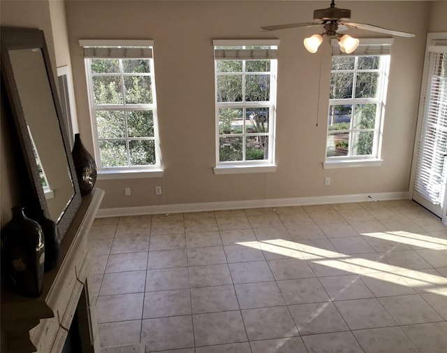 tiled empty room featuring ceiling fan