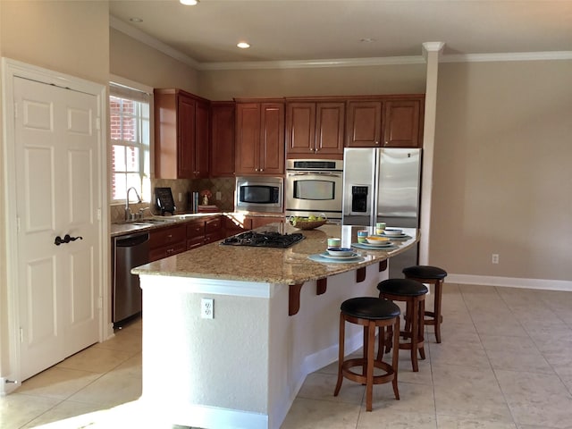 kitchen featuring appliances with stainless steel finishes, a center island, light tile patterned flooring, light stone countertops, and sink