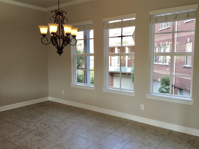 spare room featuring crown molding, tile patterned floors, and an inviting chandelier