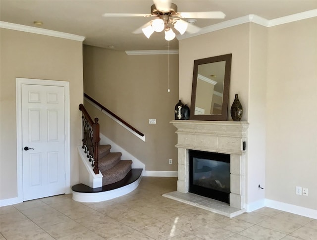 staircase featuring ceiling fan, a fireplace, tile patterned floors, and ornamental molding