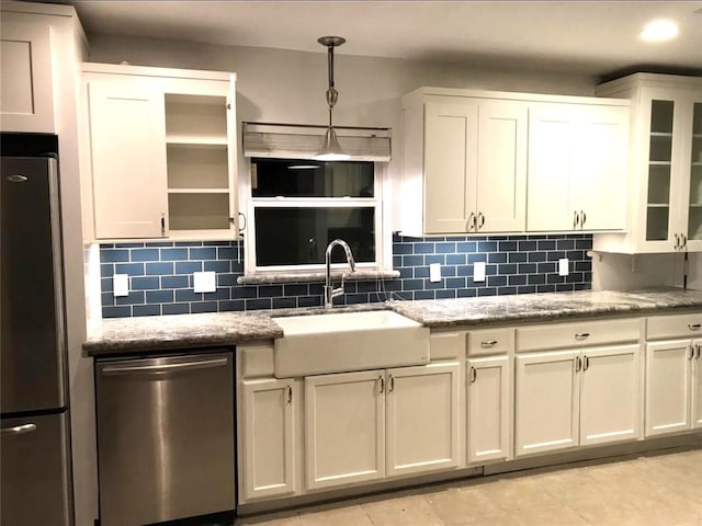 kitchen featuring pendant lighting, white cabinets, sink, appliances with stainless steel finishes, and tasteful backsplash