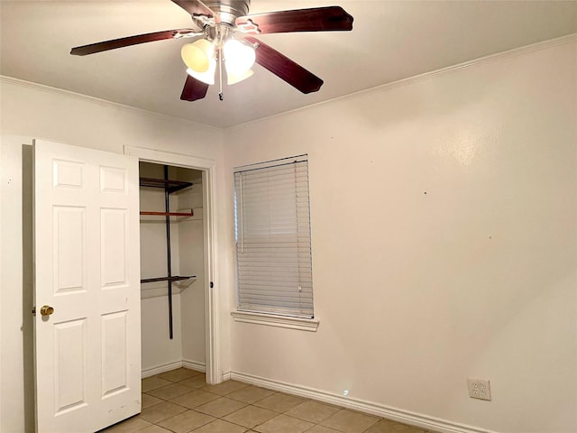 unfurnished bedroom with ceiling fan, a closet, light tile patterned floors, and crown molding