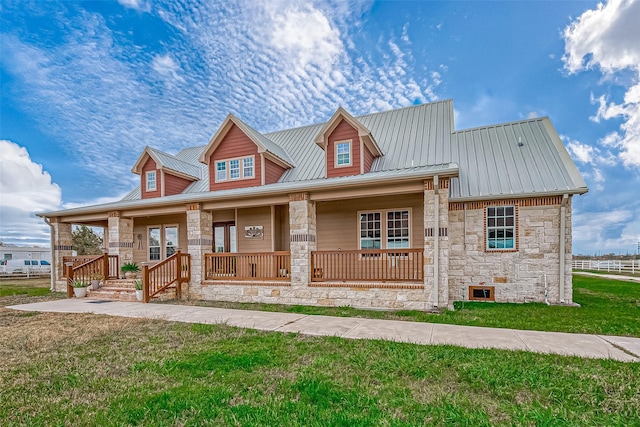 view of front of home with covered porch and a front lawn