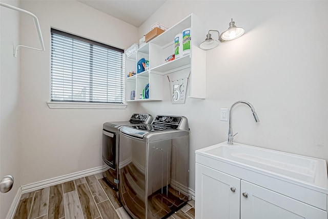 clothes washing area with washing machine and dryer and cabinets