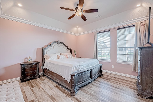 bedroom featuring a tray ceiling, ceiling fan, and light wood-type flooring