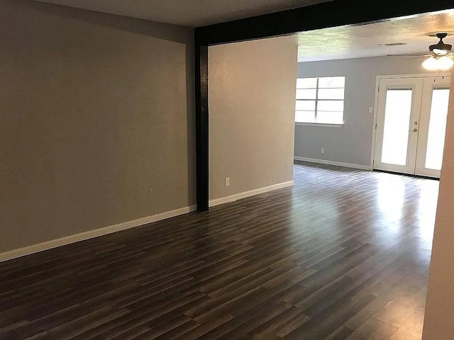 unfurnished room featuring ceiling fan, french doors, and dark wood-type flooring