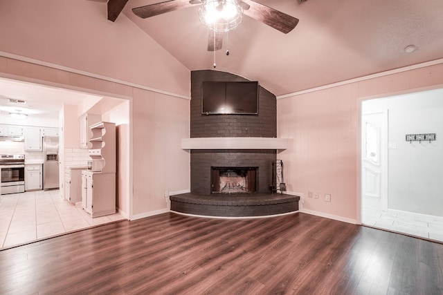 unfurnished living room with a fireplace, light wood-type flooring, lofted ceiling with beams, and ceiling fan