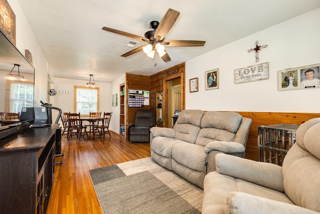 living room featuring ceiling fan and dark wood-type flooring