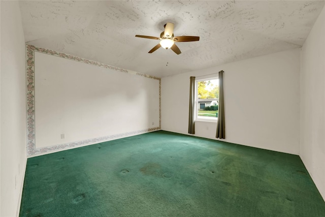 empty room featuring ceiling fan, carpet, and a textured ceiling