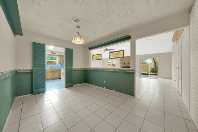 tiled spare room with ceiling fan