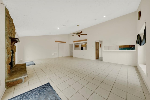 unfurnished living room with ceiling fan, light tile patterned flooring, a fireplace, and high vaulted ceiling