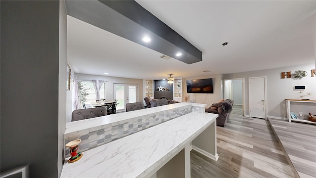 dining room featuring french doors, light wood-type flooring, ceiling fan, and built in shelves