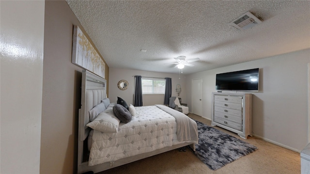 bedroom featuring ceiling fan, light colored carpet, and a textured ceiling