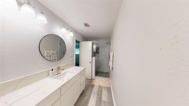 bathroom with hardwood / wood-style flooring, vanity, and an enclosed shower