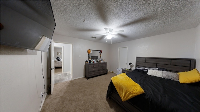 carpeted bedroom with ceiling fan and a textured ceiling