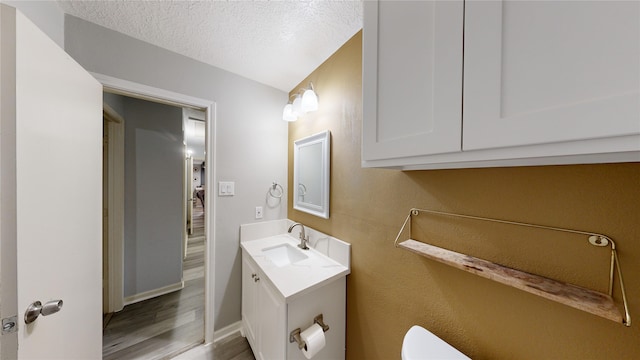 bathroom with vanity, hardwood / wood-style floors, and a textured ceiling