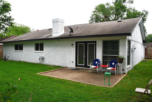 back of house with a yard and a patio