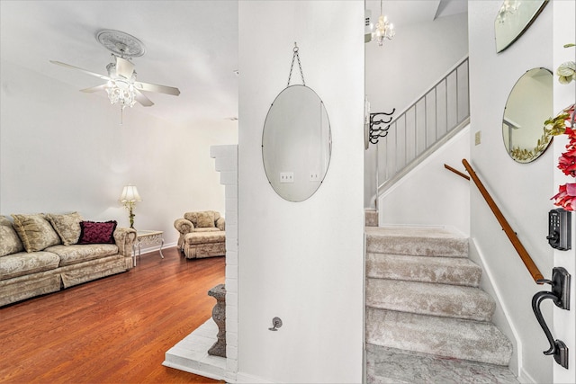 stairs featuring hardwood / wood-style floors and ceiling fan