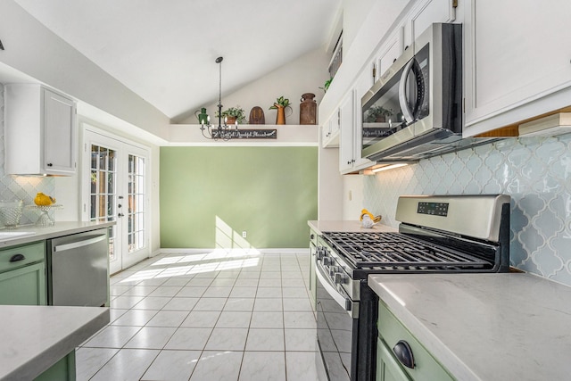 kitchen with pendant lighting, lofted ceiling, white cabinets, green cabinetry, and stainless steel appliances