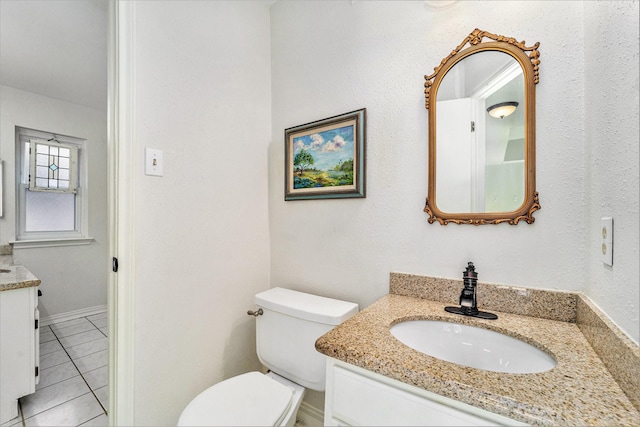 bathroom featuring vanity, tile patterned flooring, and toilet