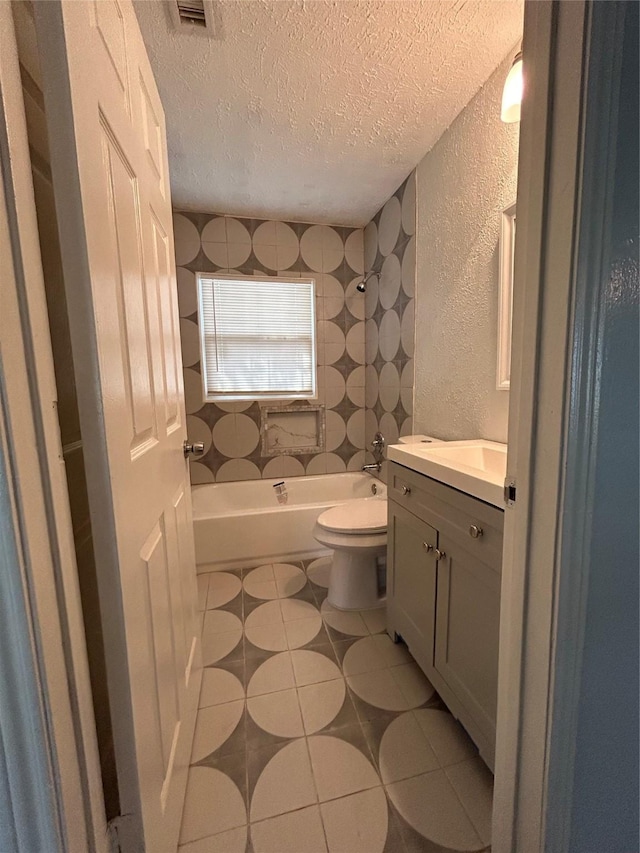 bathroom with tile patterned floors, vanity, a textured ceiling, and toilet