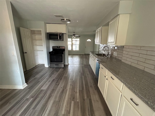 kitchen featuring dark wood-type flooring, white cabinets, sink, ceiling fan, and appliances with stainless steel finishes