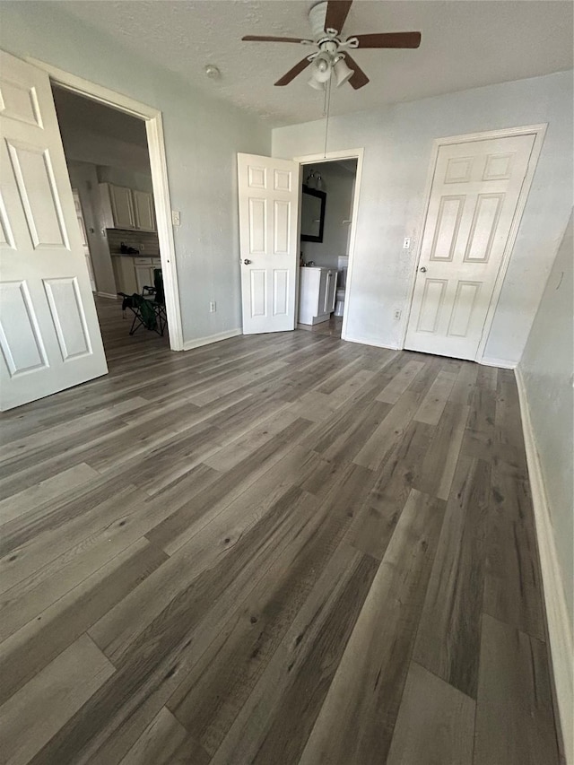 unfurnished living room with ceiling fan and dark hardwood / wood-style floors