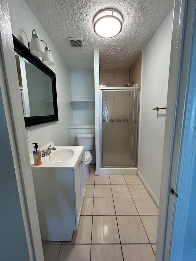 bathroom with tile patterned floors, a textured ceiling, an enclosed shower, toilet, and vanity