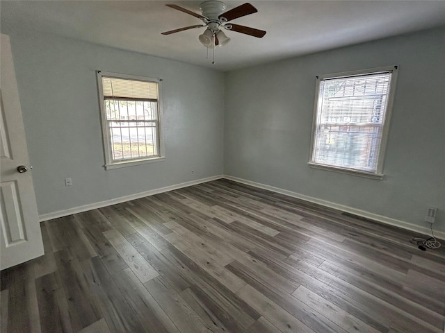 unfurnished room with ceiling fan, dark wood-type flooring, and a wealth of natural light