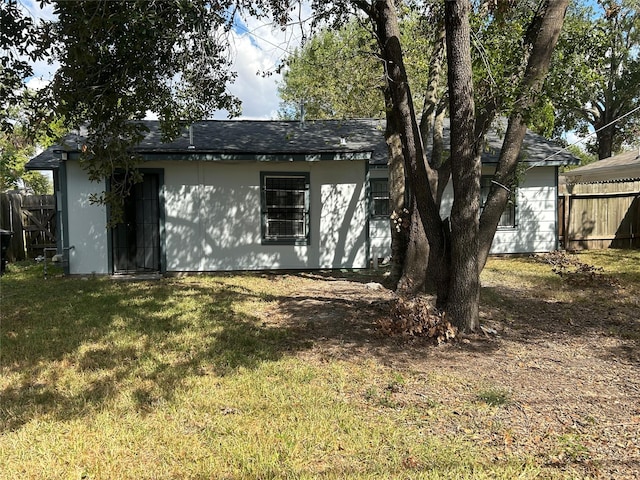 rear view of property featuring a lawn