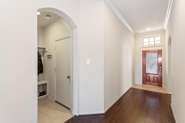 entryway featuring wood-type flooring and ornamental molding