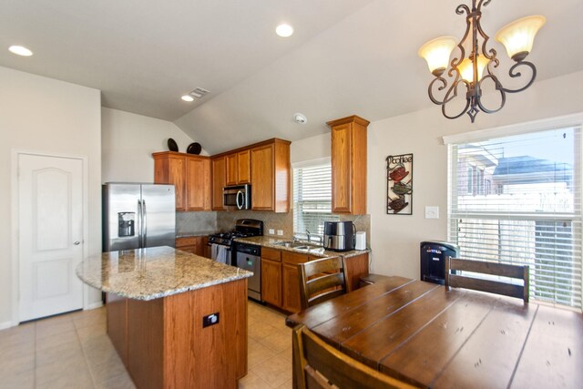 kitchen with pendant lighting, an inviting chandelier, sink, vaulted ceiling, and stainless steel appliances