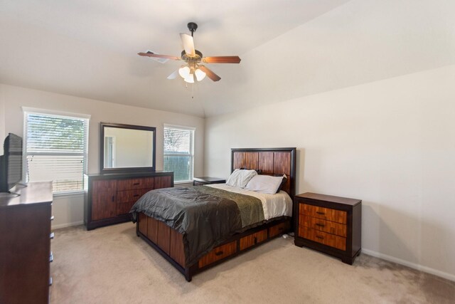 carpeted bedroom with ceiling fan and vaulted ceiling