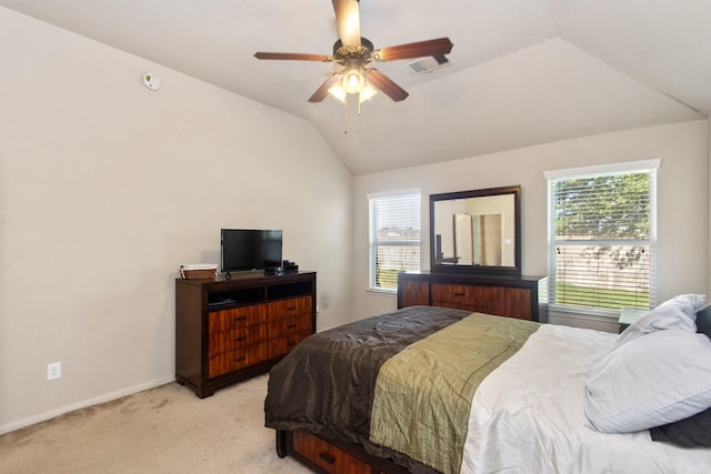 bedroom with ceiling fan, vaulted ceiling, light colored carpet, and multiple windows