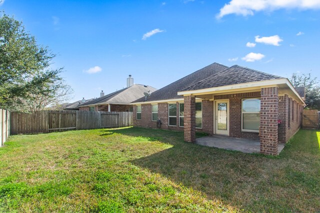 rear view of house featuring a patio and a lawn