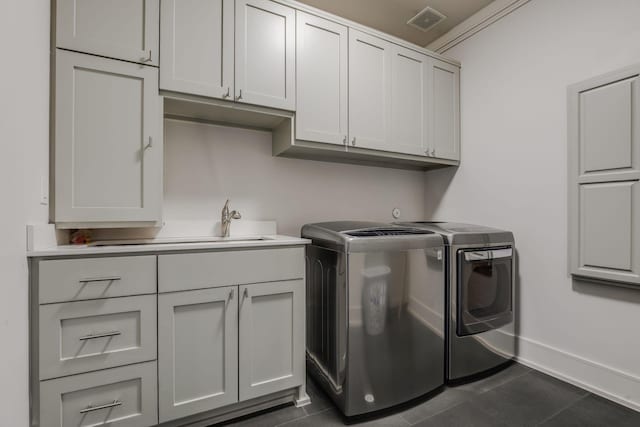 laundry room featuring cabinets, washing machine and dryer, and ornamental molding