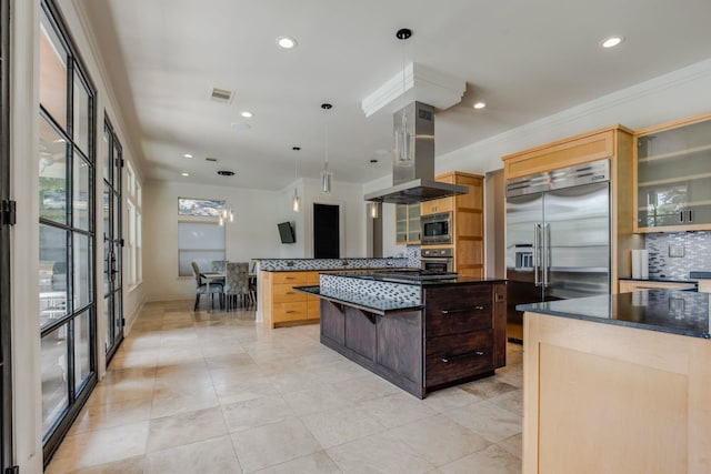 kitchen featuring island exhaust hood, ornamental molding, pendant lighting, built in appliances, and a center island