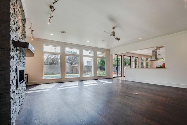 unfurnished living room featuring hardwood / wood-style flooring, ceiling fan, crown molding, and a fireplace