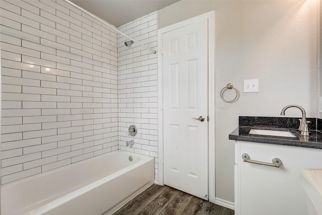 bathroom with vanity, wood-type flooring, and tiled shower / bath combo