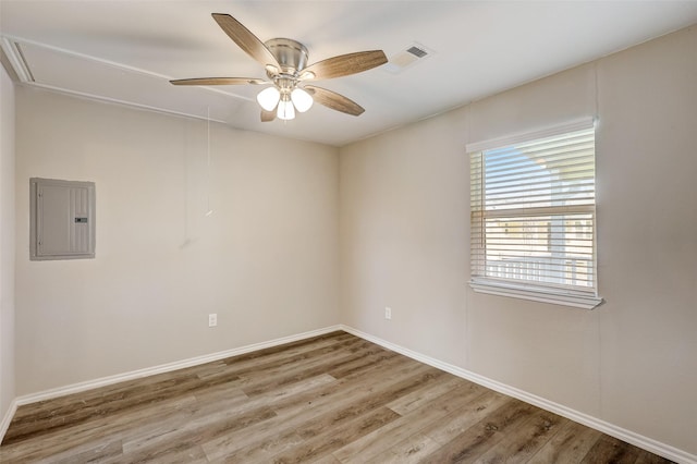 spare room featuring hardwood / wood-style flooring, ceiling fan, and electric panel