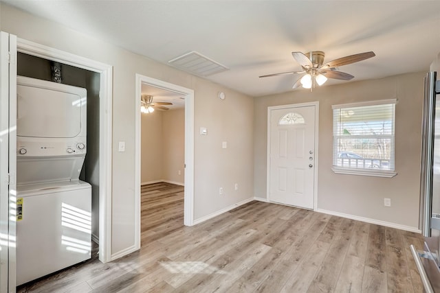 entrance foyer featuring stacked washer and dryer, ceiling fan, and light hardwood / wood-style flooring