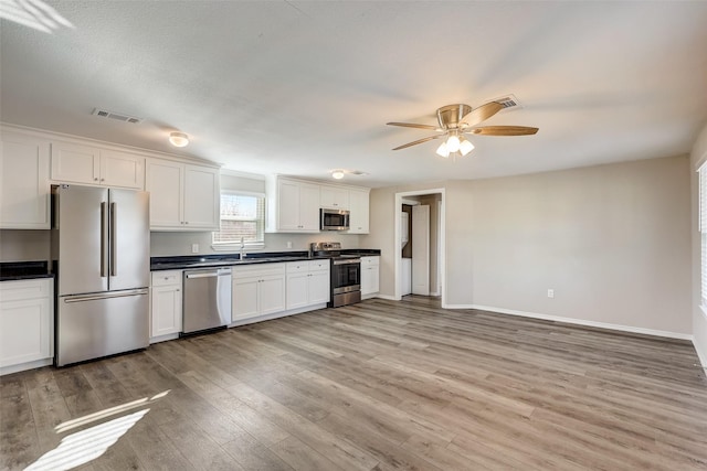 kitchen featuring appliances with stainless steel finishes, ceiling fan, sink, light hardwood / wood-style flooring, and white cabinets