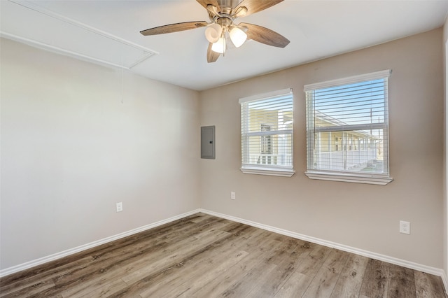 empty room with light wood-type flooring, electric panel, and ceiling fan